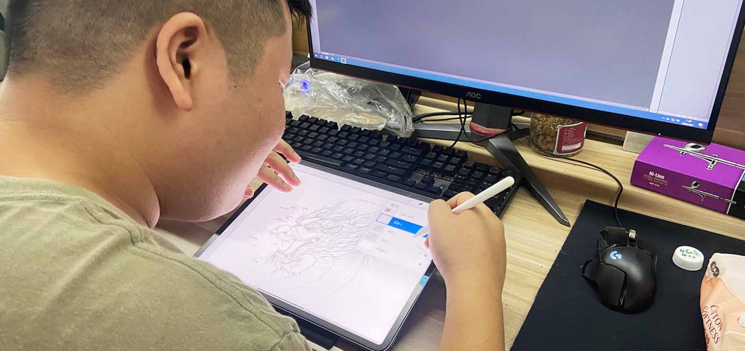 The lantern designer is using a tablet to sketch a design for a Chinese lantern.