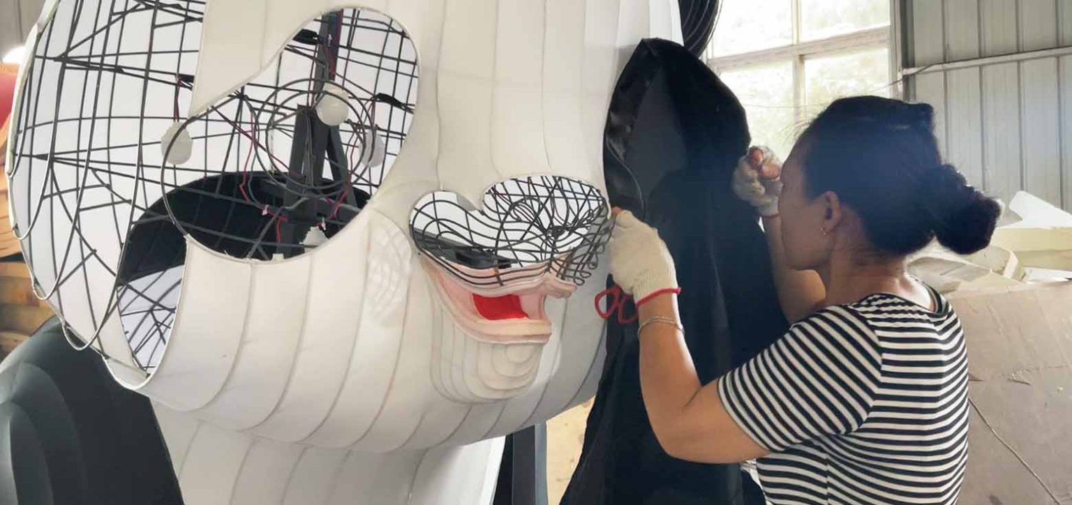 Workers are papering a giant panda lantern.