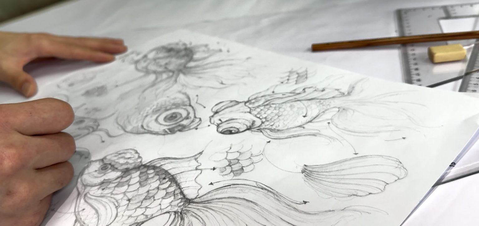 The designer is drawing a design draft for the goldfish lantern.