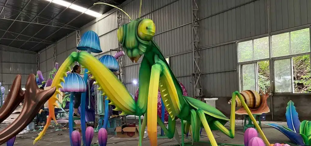 A large, vivid praying mantis-shaped Chinese insect lantern.