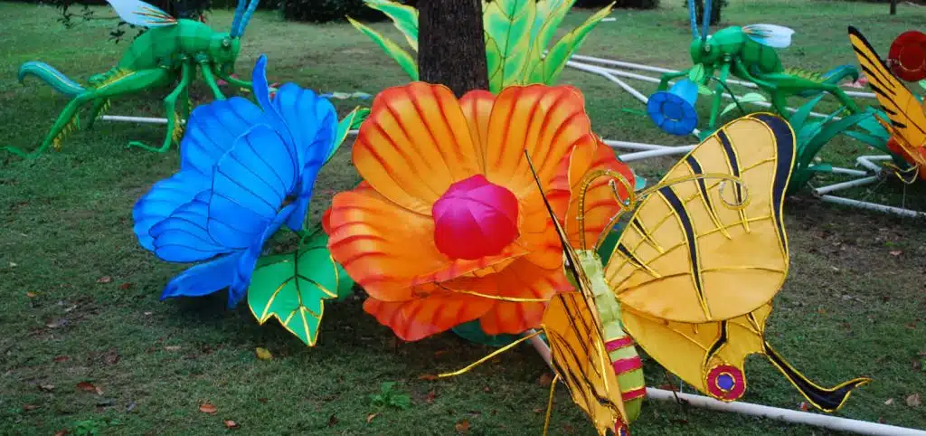 A vivid scene of butterflies gathering nectar, created by Chinese lantern lights installations in an outdoor park.