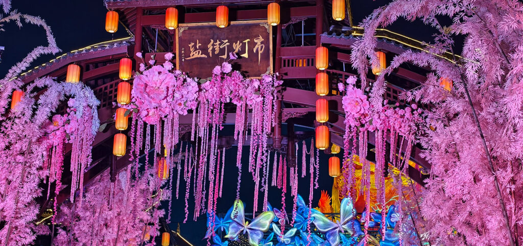 BLOG 15 Une porte de marché de lanternes traditionnelle ornée de lanternes florales roses, évoquant des classiques histoires de la fête de la mi-automne.