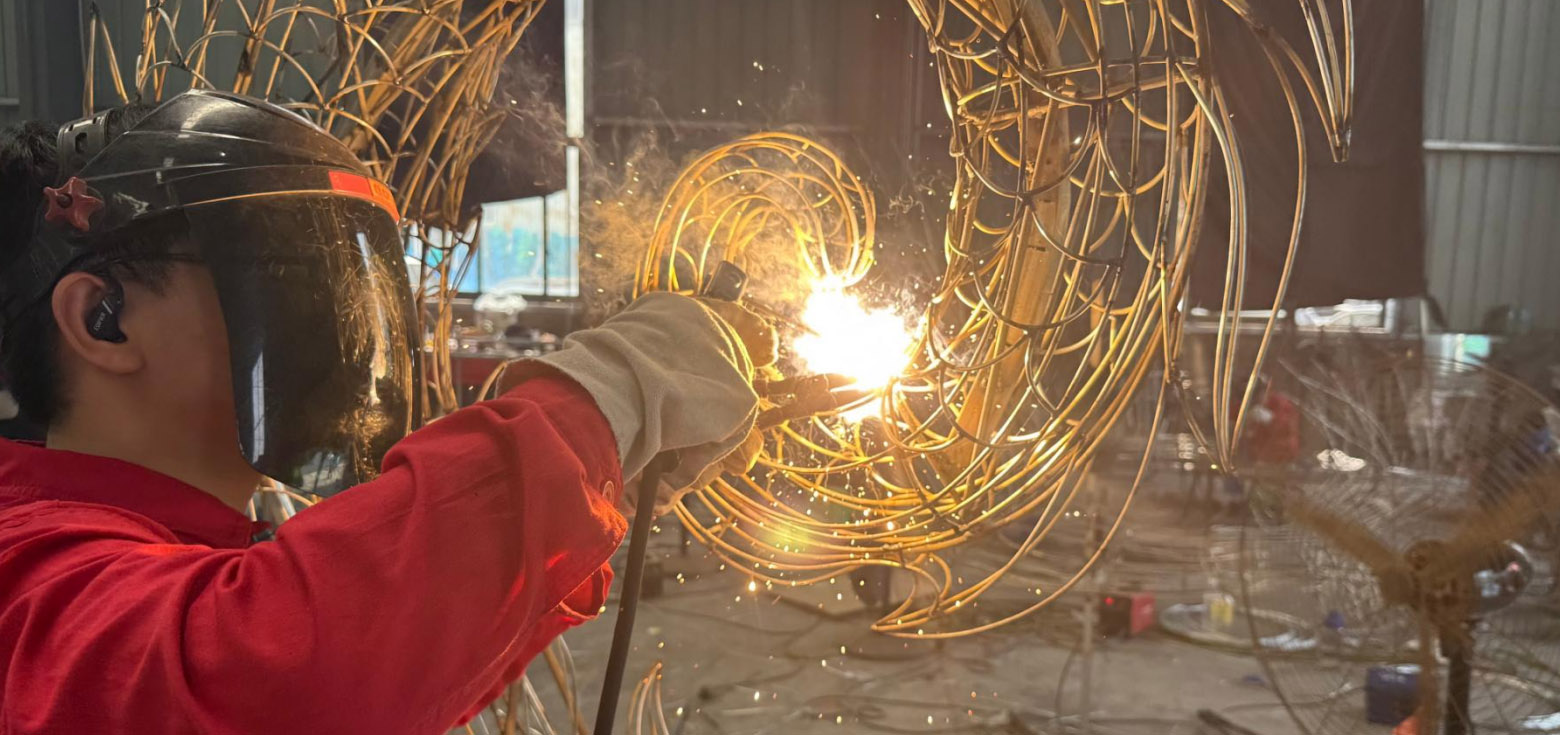 Custom IP Structures 8 Welder shaping an intricate steel armature during our commercial lantern fabrication process.