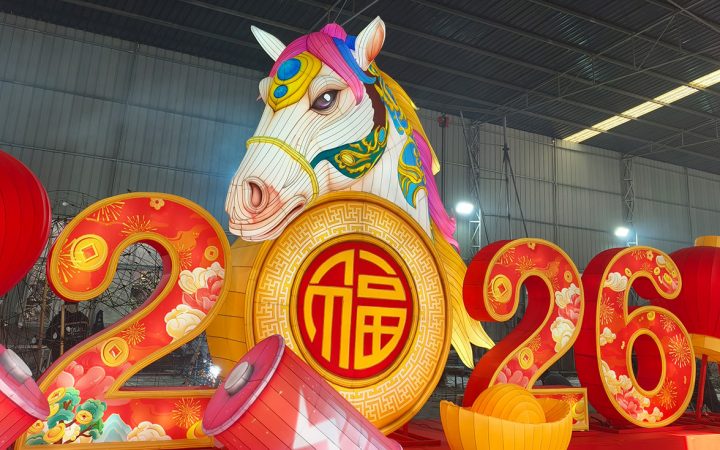 Grande pièce maîtresse illuminée de lanternes de l'année du cheval 2026 dans un cadre d'usine.
