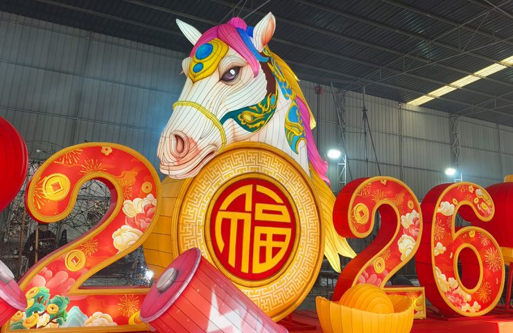 Large illuminated 2026 year of the horse lanterns centerpiece in a factory setting.