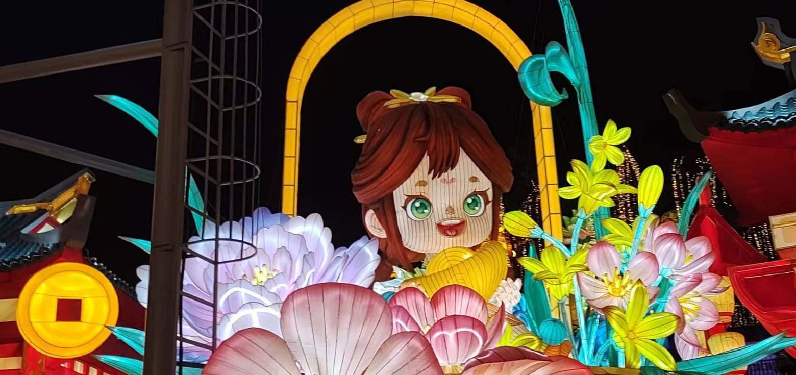 A charming cartoon girl-shaped lantern group encircled by numerous floral lanterns.