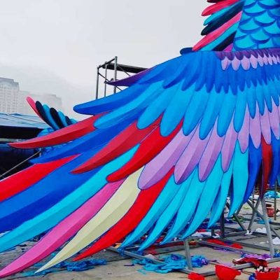 The workers are cutting and coloring a large, modern, fantasy lantern.