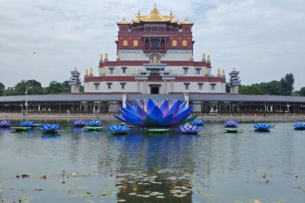 On the lake in front of the temple, a cluster of blue lotus-shaped floating water lanterns are quietly drifting.