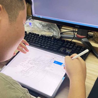 The lantern designer is using a tablet to sketch a design for a Chinese lantern.