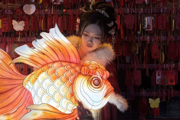 On Lantern Festival night, a Hanfu-clad girl holds a goldfish lantern.
