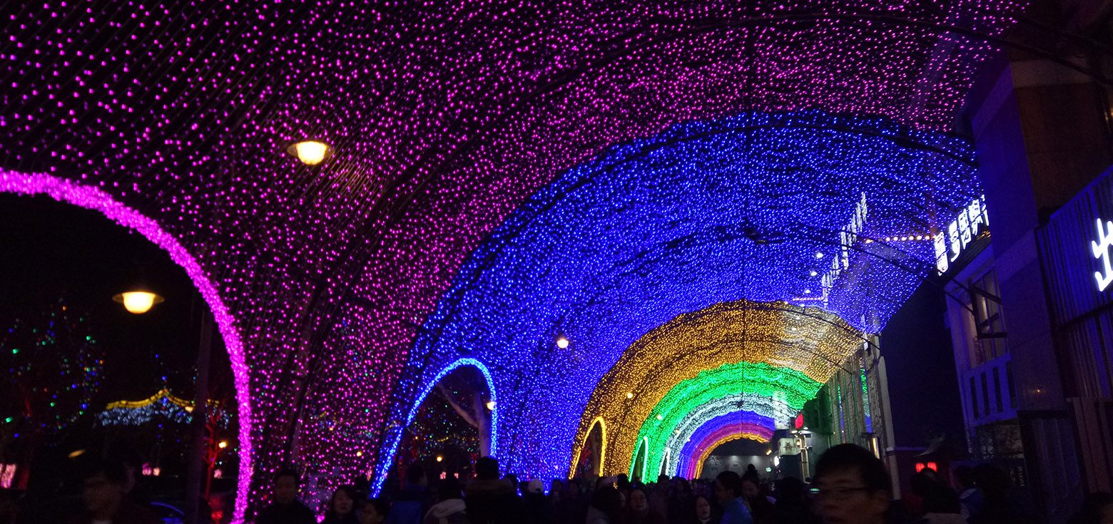 The brilliant, multi-colored outdoor lighting decorations on the street.