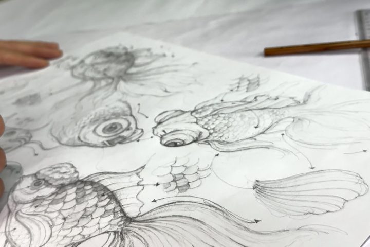 The designer is drawing a design draft for the goldfish lantern.