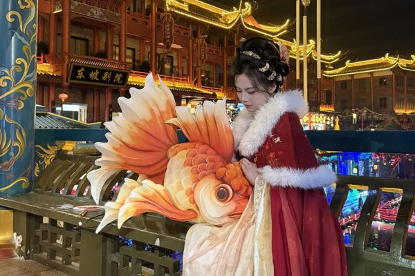 Lanterne traditionnelle chinoise : une jeune fille vêtue d'un hanfu tenant une lanterne en forme de poisson rouge